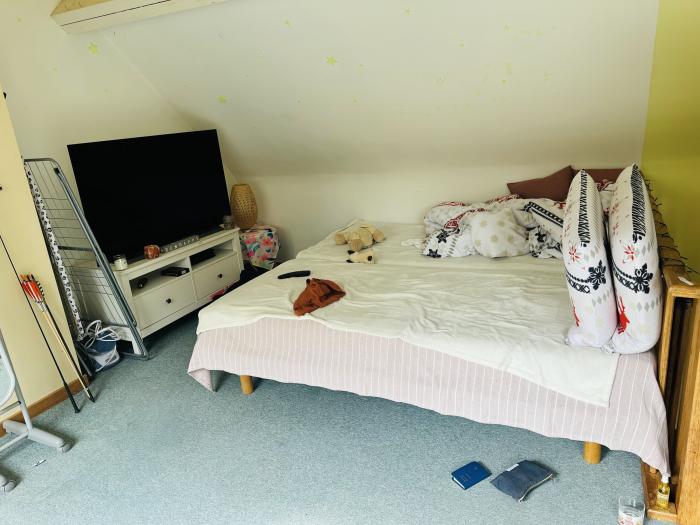 Une chambre avec lit d’1m80, des armoires, un bureau.